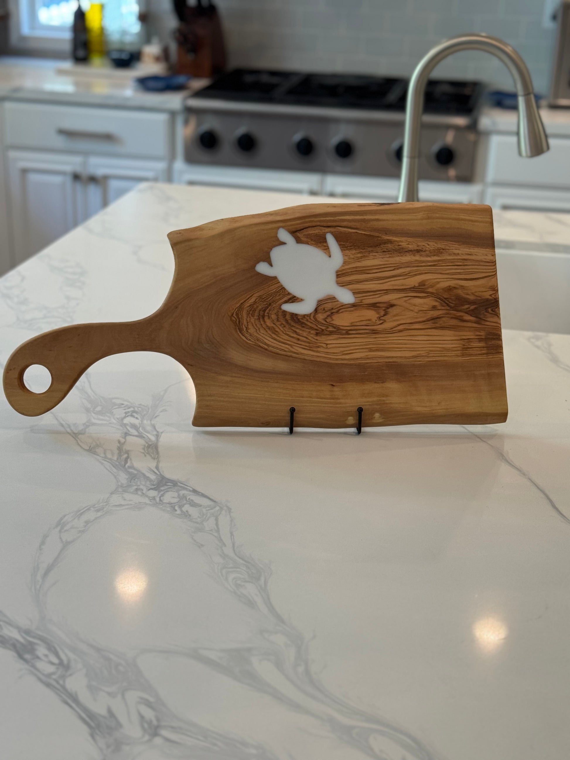 Wooden serving board with a turtle design on a kitchen counter